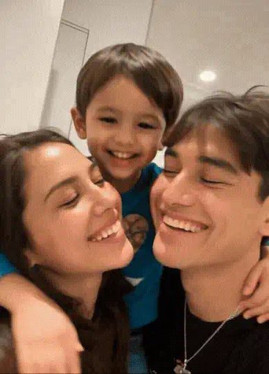 AI baby generator video: an AI-made toddler squeezes in between a smiling couple taking a selfie